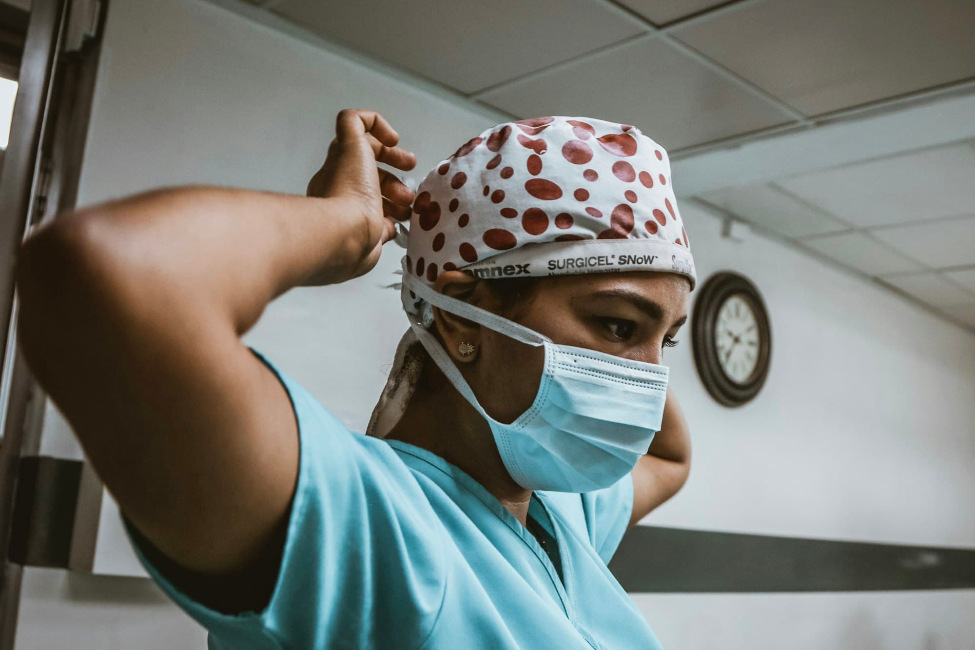 Nurse adjusting a surgical cap