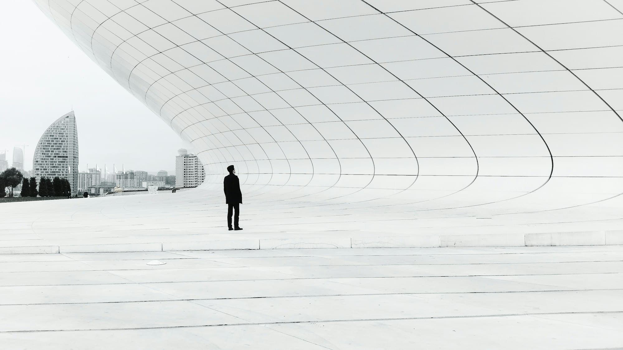 A lone figure standing in a vast white space